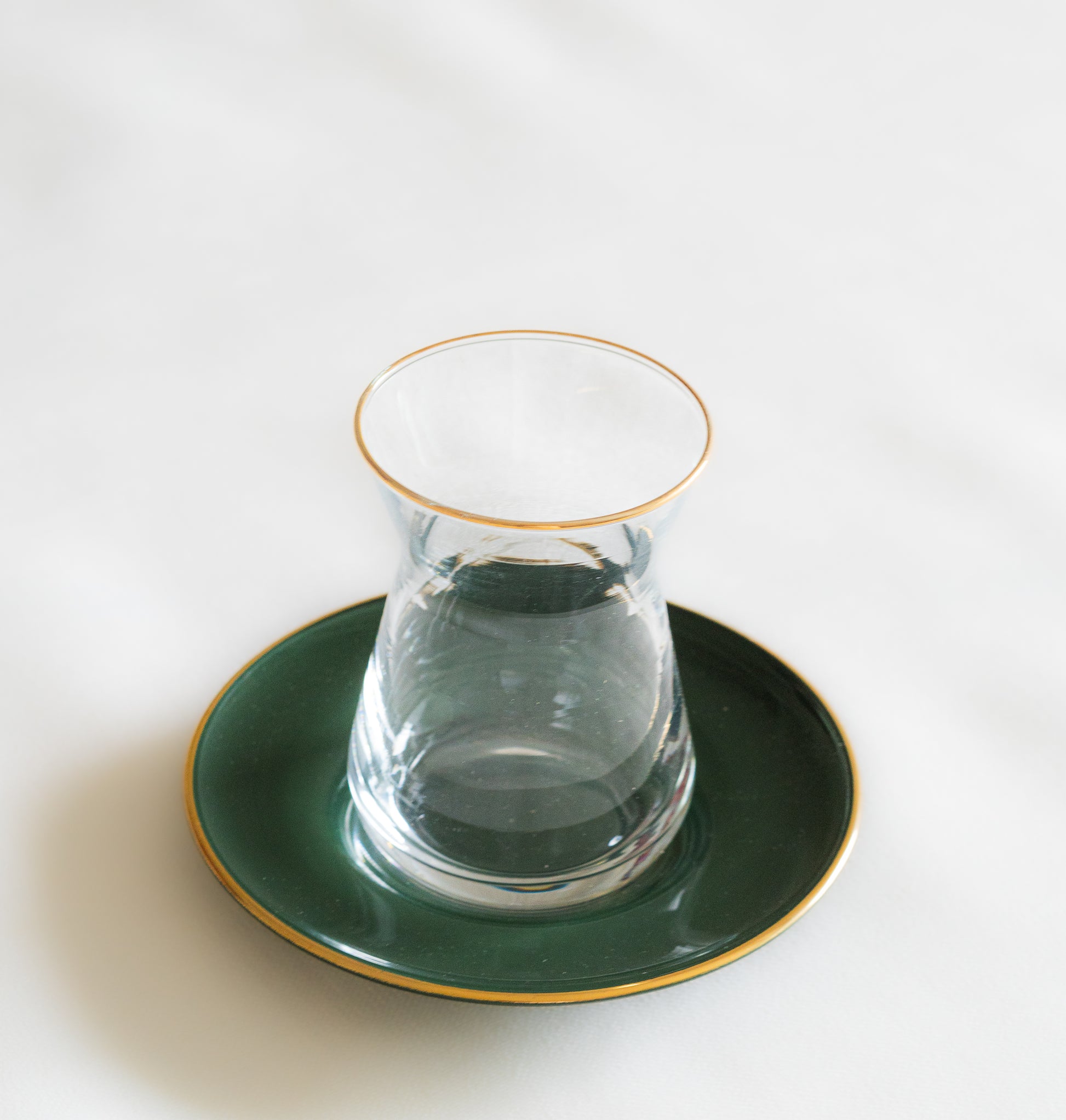 verres à the ethiques inspires du Maroc vert avec des accents dores évoquant une atmosphère chaleureuse et authentique.