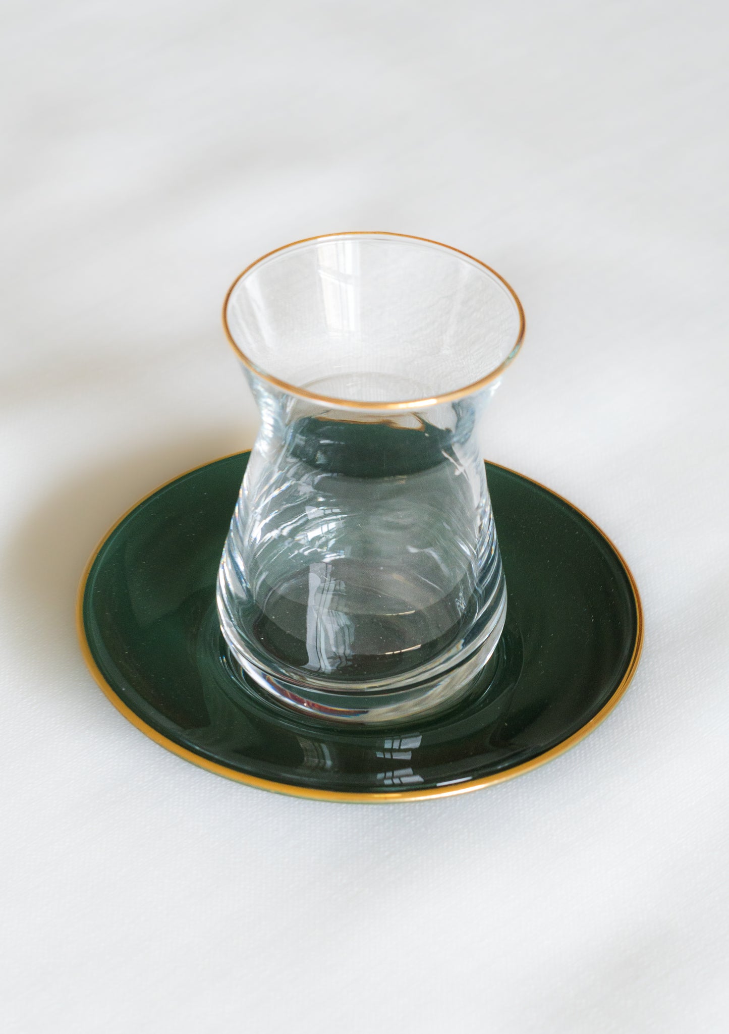verres à the couleur vert du Maroc avec une bordure doree poses sur des soustasses assorties pour une atmosphere authentique