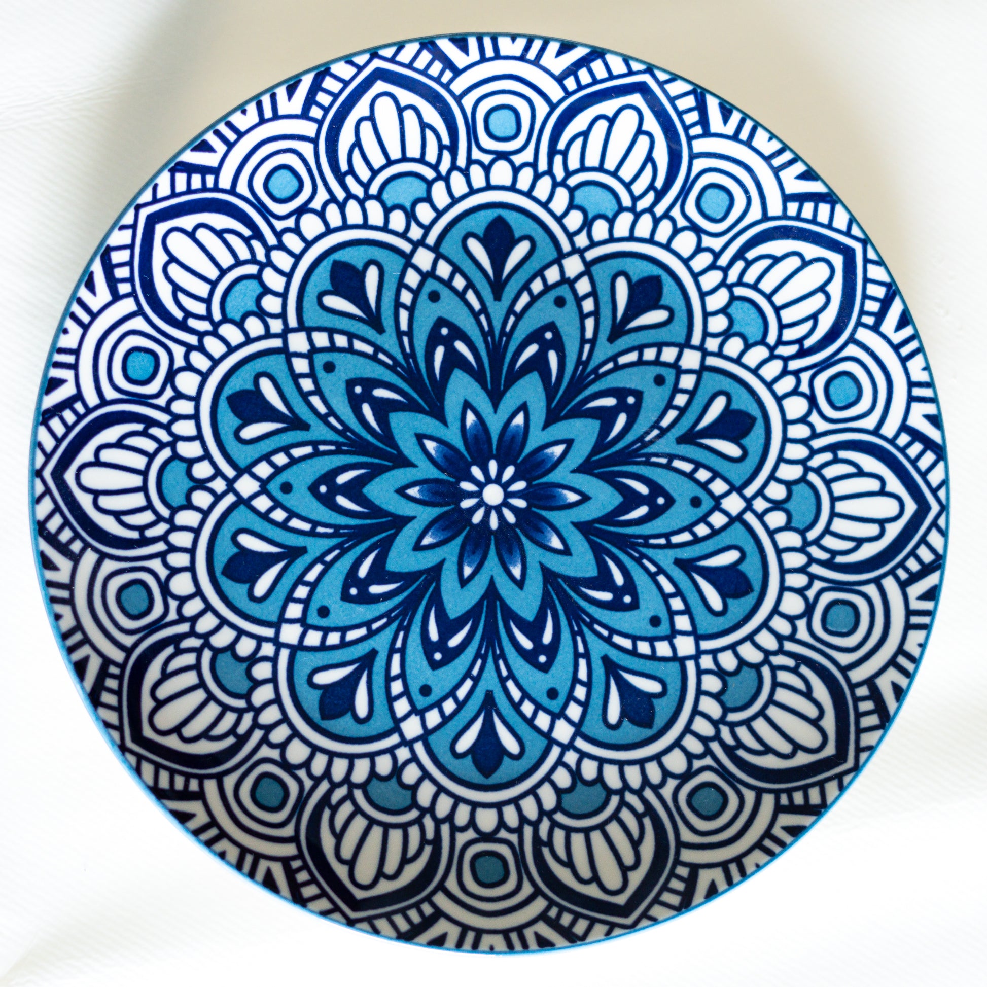 Une assiette en porcelaine de Chefchaouen, teintée de nuances bleues profondes reflétant l'authenticité du Maroc et apportant un éclat unique à la décoration des maisons